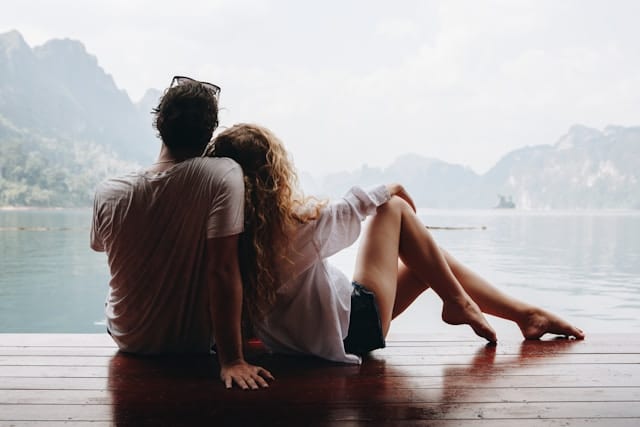 Couple assis de dos face à un lac, en lien avec le parcours de fertilité et l’exploration du spermogramme.