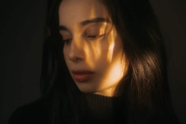 Lumière dorée sur le visage d’une femme illustrant la fatigue ovarienne invisible