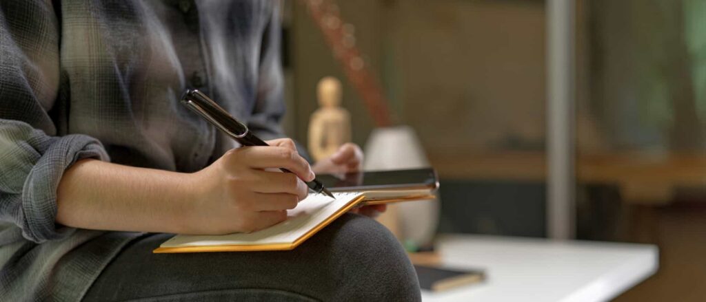 Main qui annote un bilan biologique sanguin avec stylo, lecture clinique en accompagnement de la fertilité