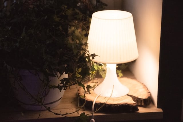 Lampe allumée dans un salon en fin de soirée, ambiance de nuit écourtée